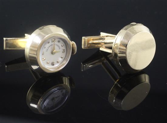 A pair of 14k gold circular cufflinks, one with inset timepiece and winding crown, the dial inscribed Seaman Schepps.